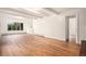 Bright living room featuring hardwood floors, white walls, large window, and built in shelving at 3306 S Uinta Ct, Denver, CO 80231
