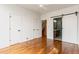 Spacious bedroom with hardwood floors, multiple doors, and a glimpse into an ensuite bathroom at 2680 Blake St # 4, Denver, CO 80205