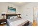 Modern bedroom with a plush bed, stylish bedside tables, a sleek headboard, and hardwood floors at 2680 Blake St # 4, Denver, CO 80205