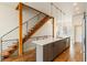 Modern kitchen island with seating, natural wood staircase, and bright, open layout at 2680 Blake St # 4, Denver, CO 80205