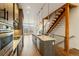 Contemporary kitchen with island, stainless appliances, and open staircase access at 2680 Blake St # 4, Denver, CO 80205