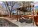 Cozy backyard patio features wicker furniture and pergola with a wooden fence and mature trees at 3124 W 26Th Ave, Denver, CO 80211