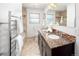 Bright bathroom featuring double vanity, granite countertops, decorative tile and a heated towel rack at 801 S Harrison St, Denver, CO 80209