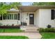 Close-up of front door with modern lighting, manicured flower beds, and freshly painted white brick at 801 S Harrison St, Denver, CO 80209
