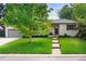 Charming one-story home featuring a lush green lawn and a classic painted brick exterior at 801 S Harrison St, Denver, CO 80209