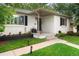 Inviting covered front porch with well-maintained landscaping and a freshly painted white brick exterior at 801 S Harrison St, Denver, CO 80209