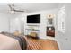 Primary bedroom with hardwood floors, ceiling fan, a tv, and an ensuite bathroom at 801 S Harrison St, Denver, CO 80209