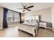 Bright bedroom with a large window, a ceiling fan, and a well-made bed on light wood floors at 10246 Tall Oaks Cir, Parker, CO 80134