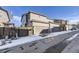 Three-story townhome with a two-car garage and snow on the ground at 10246 Tall Oaks Cir, Parker, CO 80134