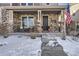 Inviting covered porch with stone details, wicker chairs, and American flag at 10246 Tall Oaks Cir, Parker, CO 80134