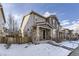 Two story townhome with stone accents and snow covered yard at 10246 Tall Oaks Cir, Parker, CO 80134