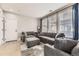 Living room with gray sofas, ottoman, and ample natural light from large windows at 10246 Tall Oaks Cir, Parker, CO 80134