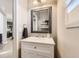 Small powder room with white vanity and a framed mirror at 10246 Tall Oaks Cir, Parker, CO 80134