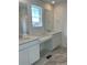 Bathroom with double sink vanity, quartz countertop, tiled floors, and natural light at 28644 E 7Th Ave, Watkins, CO 80137