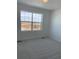 Empty bedroom with wall-to-wall carpeting and a large window overlooking a construction site at 28644 E 7Th Ave, Watkins, CO 80137