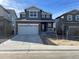 Two-story home featuring a two car garage and stone and siding details under a clear blue sky at 28644 E 7Th Ave, Watkins, CO 80137