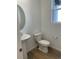 Stylish powder room featuring a pedestal sink, modern toilet, and wood look flooring at 28644 E 7Th Ave, Watkins, CO 80137