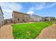 Wide shot of backyard with small, grassy area, wood fences, and stone landscaping at 7465 E 157Th Pl, Thornton, CO 80602