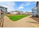A grassy lawn and gravel area are enclosed by a rustic wood fence in this attractive backyard at 7465 E 157Th Pl, Thornton, CO 80602