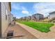 Backyard with a small patch of grass surrounded by a rock garden and wooden fences at 7465 E 157Th Pl, Thornton, CO 80602