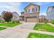 Two story home featuring a stone facade and manicured lawn at 7465 E 157Th Pl, Thornton, CO 80602