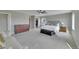 Bright main bedroom with a walk-in closet, light gray walls, a large bed, and soft carpeting at 7465 E 157Th Pl, Thornton, CO 80602