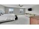 Spacious main bedroom with a ceiling fan, large windows, a sofa, and a television at 7465 E 157Th Pl, Thornton, CO 80602