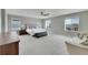 Bright main bedroom featuring soft carpet, a large bed, and views of the surrounding neighborhood at 7465 E 157Th Pl, Thornton, CO 80602