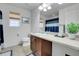 A well-lit bathroom with a single sink vanity, neutral tiling, and a large mirror at 9868 Olathe St, Commerce City, CO 80022