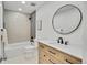 Stylish bathroom features a modern vanity, round mirror, and a shower-tub combo with tiled walls at 1226 W 98Th Ave, Northglenn, CO 80260