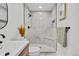 Clean bathroom with walk-in shower featuring gray tile and seat plus new toilet and single sink vanity at 1226 W 98Th Ave, Northglenn, CO 80260