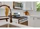 Contemporary kitchen featuring white cabinets, stainless steel appliances, and a stylish bronze faucet at 1226 W 98Th Ave, Northglenn, CO 80260