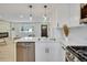 Bright white kitchen with stainless steel appliances and modern pendant lighting at 1226 W 98Th Ave, Northglenn, CO 80260
