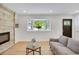 Inviting living room featuring a cozy sofa, wood accent wall, and bright bay window at 1226 W 98Th Ave, Northglenn, CO 80260