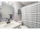 Stylish bathroom with patterned mirror frame, circular shelf and shower with a striped curtain at 2215 E 103Rd Pl, Thornton, CO 80229