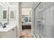 Bathroom with tiled shower and view into the main bedroom at 2215 E 103Rd Pl, Thornton, CO 80229