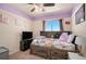 Bright bedroom with ceiling fan and large window with built-in headboard and pull out drawers for additional storage at 2215 E 103Rd Pl, Thornton, CO 80229