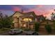 Condo building exterior with multiple balconies and well-maintained landscaping at dusk at 23456 E 5Th Pl # 104, Aurora, CO 80018