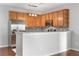 Open kitchen with wood cabinetry, stainless steel appliances, and a mosaic tile backsplash at 23456 E 5Th Pl # 104, Aurora, CO 80018