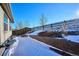 Snowy backyard with retaining wall and wooden fence at 186 Back Nine Dr, Castle Pines, CO 80108