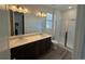 Bright bathroom featuring double sinks, granite countertops, and a glass-enclosed shower at 2668 Simpson Ln, Erie, CO 80026