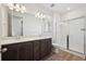 Modern bathroom with a double sink vanity, a glass-enclosed shower, and wood-look flooring at 2668 Simpson Ln, Erie, CO 80026