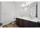 Bathroom with dual sinks and a large mirror, complemented by wood-look flooring at 2668 Simpson Ln, Erie, CO 80026