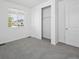 Bedroom featuring soft carpet, a closet with sliding doors, and a window overlooking the neighborhood at 2668 Simpson Ln, Erie, CO 80026
