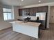 Modern kitchen with stainless steel appliances, an island with countertop and dark cabinets at 2668 Simpson Ln, Erie, CO 80026
