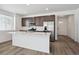 Modern kitchen with a large island, stainless steel refrigerator, and sleek cabinetry at 2668 Simpson Ln, Erie, CO 80026