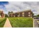 Low-angle exterior view of a brick apartment complex with a lush lawn and inviting sidewalk at 3653 S Sheridan Blvd # 16, Denver, CO 80235