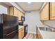 Kitchen with modern appliances and wooden cabinets at 3653 S Sheridan Blvd # 16, Denver, CO 80235