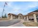 Inviting clubhouse entrance featuring stone columns, covered walkways, and a welcoming porte-cochere at 7683 S Biloxi Way, Aurora, CO 80016