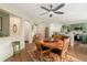 Cozy dining room with wood floors, an area rug, a ceiling fan, and an open view to the kitchen area at 7683 S Biloxi Way, Aurora, CO 80016